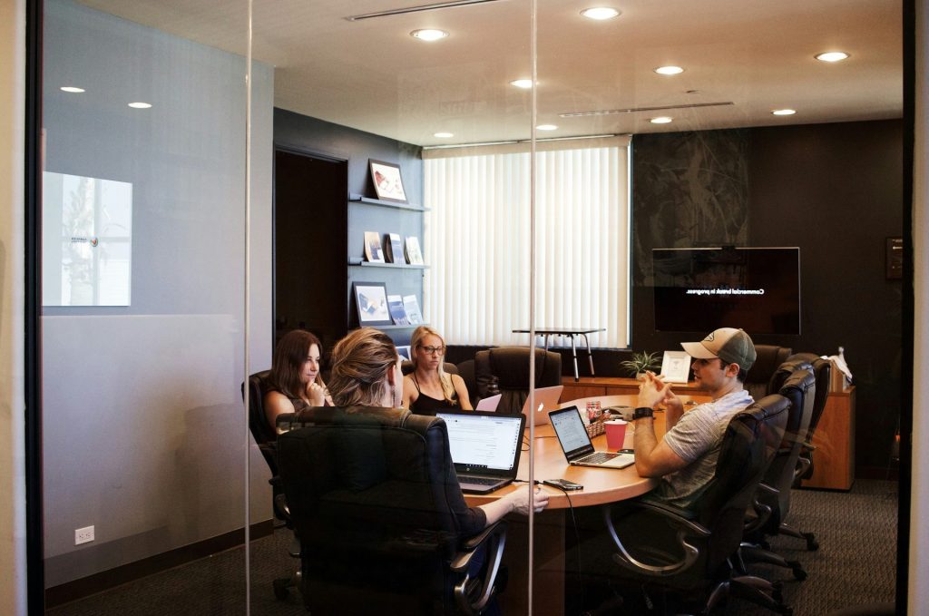 personnes assises près d'une table avec un ordinateur portable