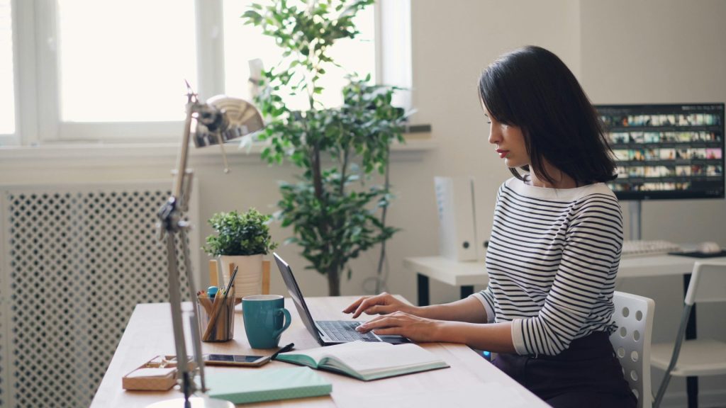 une femme assise à un bureau utilisant un ordinateur portable