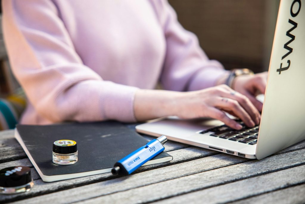 une femme assise à une table utilisant un ordinateur portable